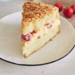 Vanilla cream cake with strawberries inside on a white table